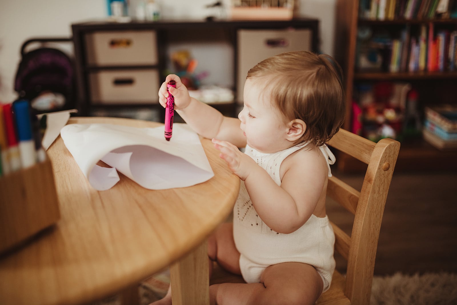 baby using a crayon on paper while sitting in a chair Dancing for Birth